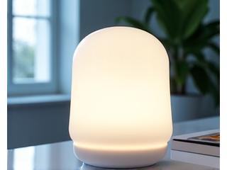 Lampa do terapii światłem emitująca jasne światło, ustawiona na biurku, służąca regulacji rytmu dobowego.